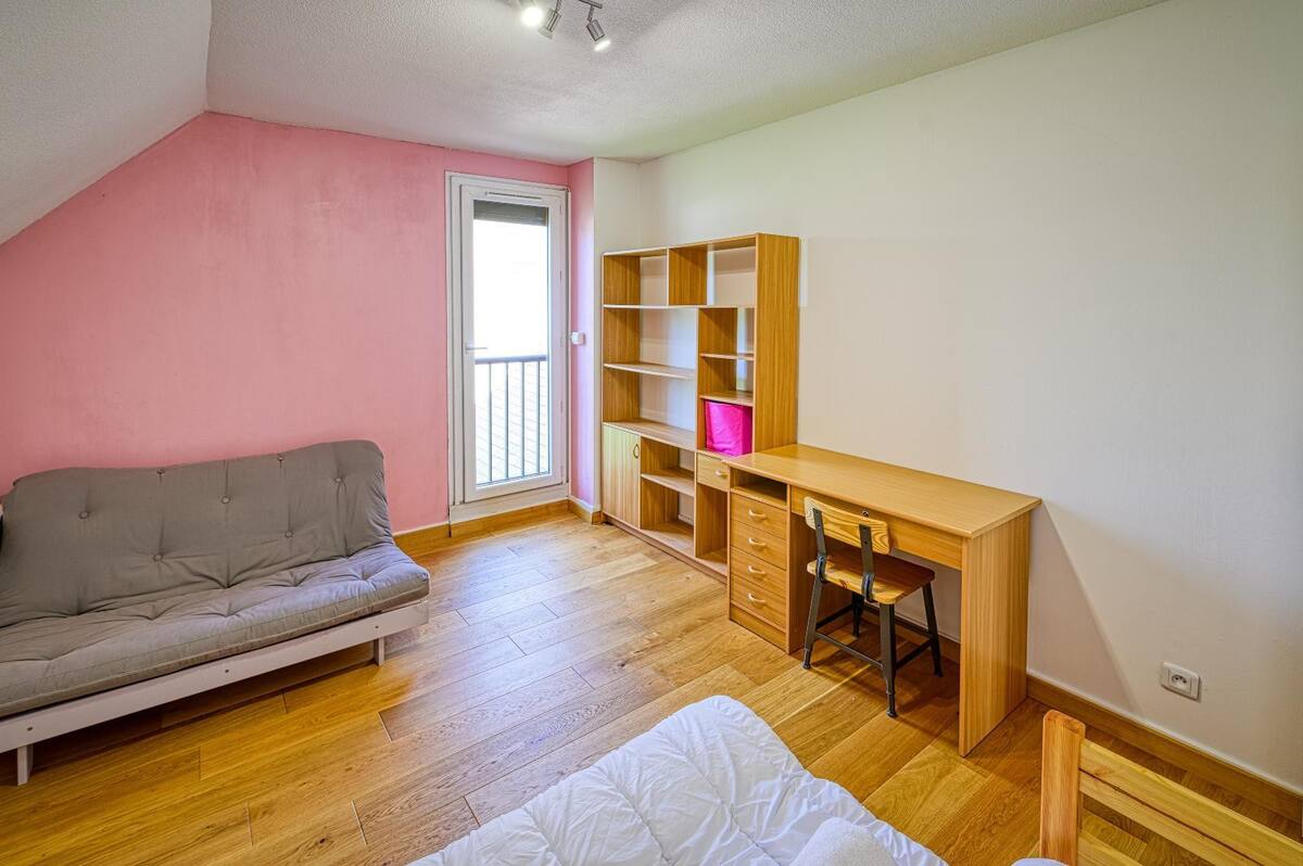 chambre avec 2 lits simples, un futon pour 2 personnes, une étagère de rangement et un bureau à l'étage