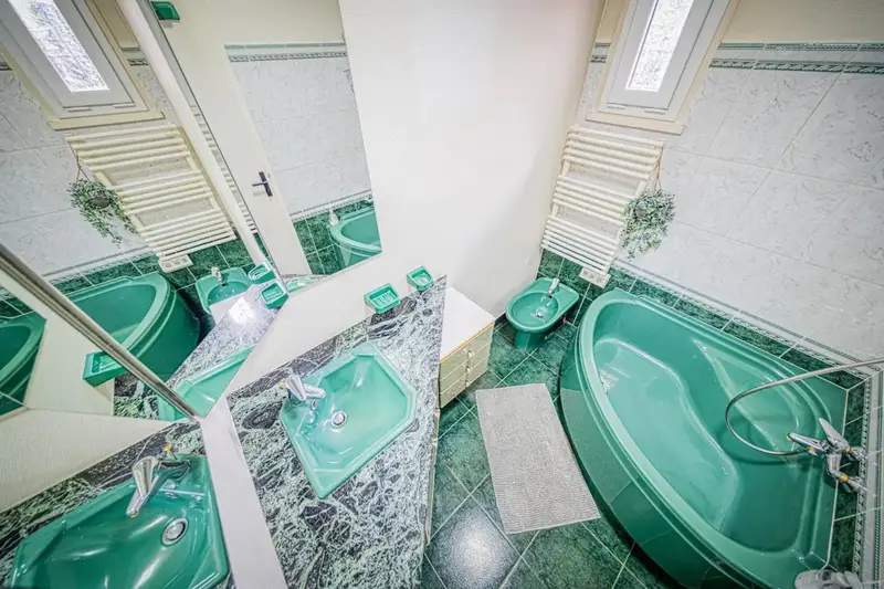 Salle de bain avec bidet, baignoire d'angle et sèche serviette