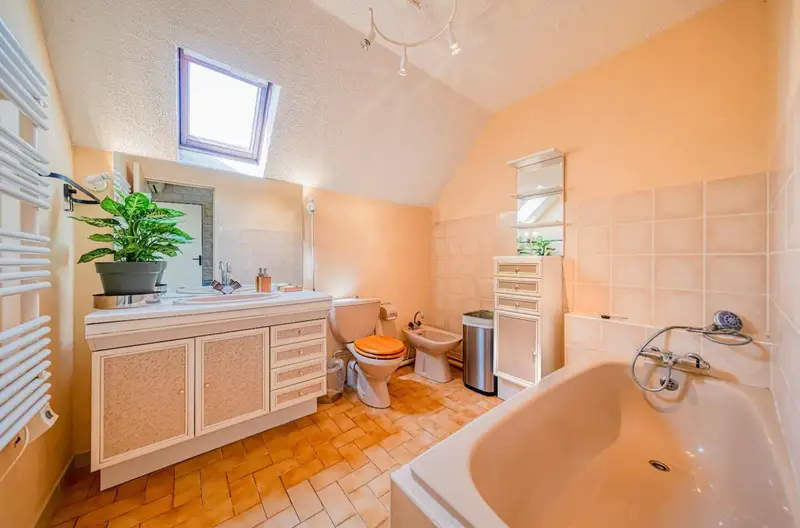 salle de bain avec baignoire, bidet, toilettes et sèche serviette à l'étage